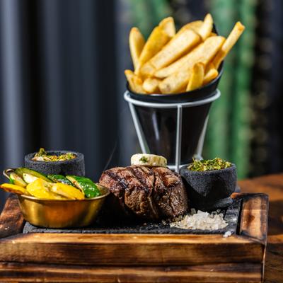 Fillet mignon served with fries, grilled vegetables and condiments.