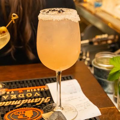 Twisted Paloma cocktail served in a wine glass with a salted rim.