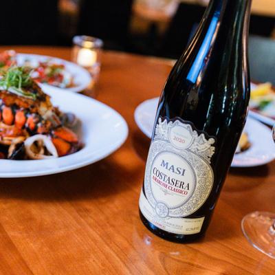 Bottle of red wine and food on the table.