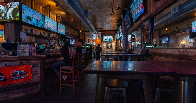 Interior, tables, chairs, bar on a side, screens above