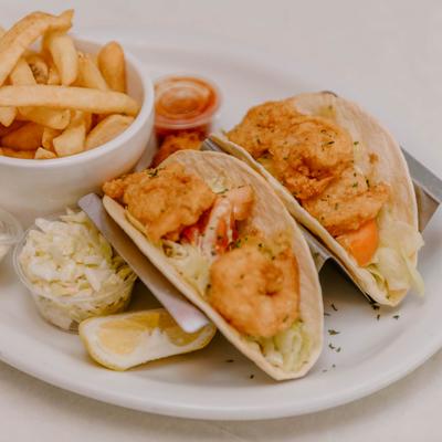 Fried shrimp tacos served with fries and coleslaw.
