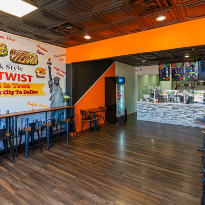 Interior featuring a mural of the Statue of Liberty, wooden counter and stools.