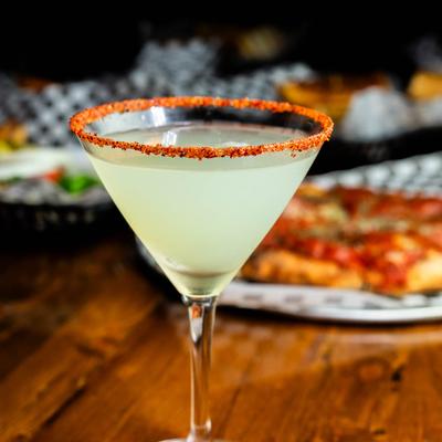 Cucumber Martini with a spiced rim, various dishes in the background.