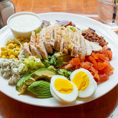 Cobb salad, with smoked chicken, avocado, corn, tomato, blue cheese, onion, egg, and bacon.