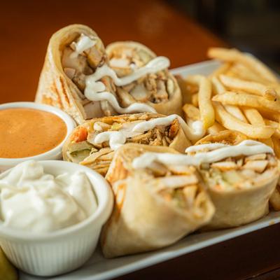 Chicken shawarma Arabic style, served with fries, veggies, and sauces for dipping.