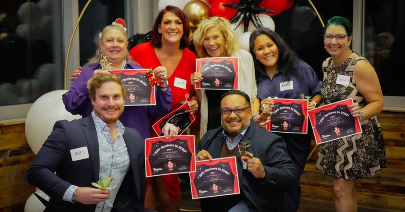 Staff members holding awards