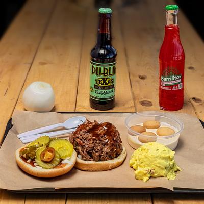 Chopped Brisket Sandwich, with banana pudding, potato salad, and drinks.