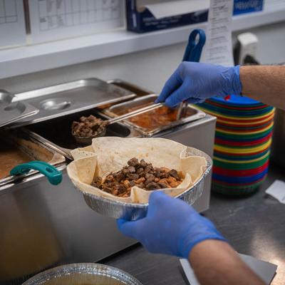 A carne asada burrito being prepared.