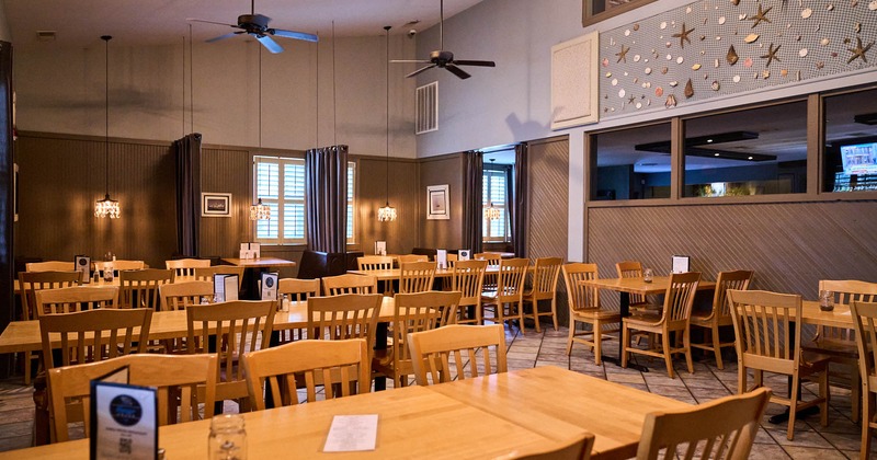 Interior, dining area, wooden chairs and tables, ceiling fans, curtain space dividers