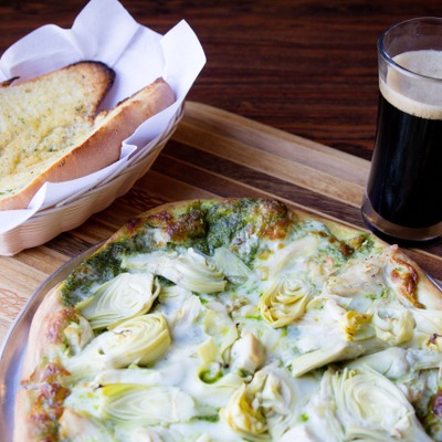 Campagnola pizza, with pesto, mozzarella, garlic, chicken, and artichoke.