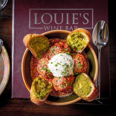 Meatballs served with toasted bread and creamy cheese.