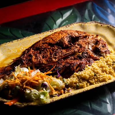Whole fried fish served with rice and a fresh shredded lettuce and carrot salad.