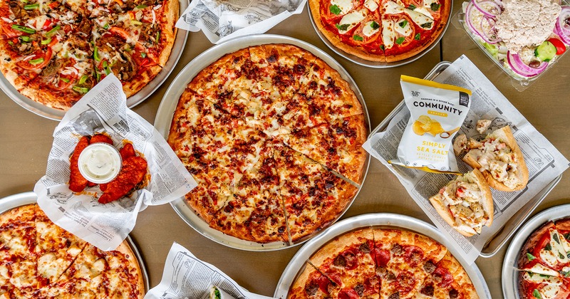 Assortment of pizzas together with various types of dishes, top view