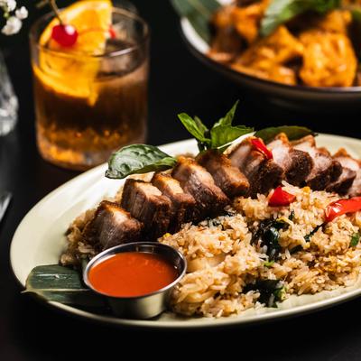 Marinated crispy pork belly served with stir-fried jasmine rice with basil and spicy chili pasta.