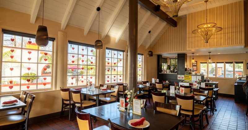 Interior, dining space wit chandeliers, tables and chairs