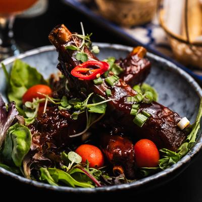 Succulent ribs glazed in a rich sauce, topped with sliced chili and greens.