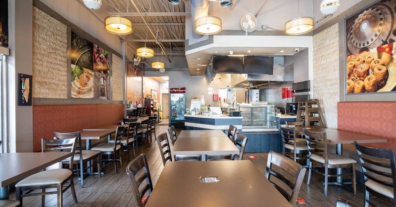 Interior of a restaurant with tables, chairs, decorative walls