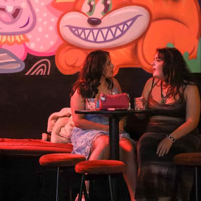 Two guests sit at a small table in the bar, engaged in conversation.