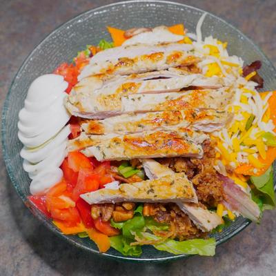 Chicken Cobb Salad,, with mixed greens, tomato, boiled eggs, bacon, cheddar, scallions, and pecans.
