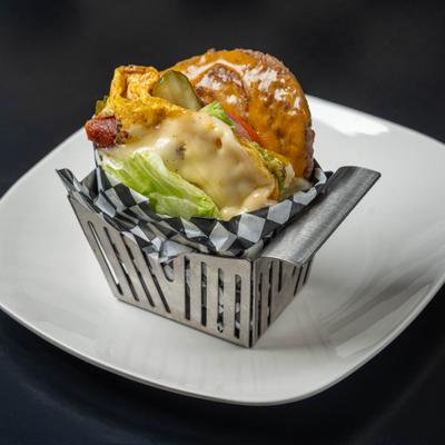 Keto Burger with bacon, scrambled egg, cheese, avocado and lettuce, served in metal fryer basket.