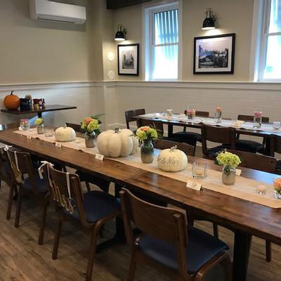 Interior, tables decorated with pumpkins and flowers.