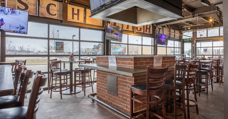 Interior, seating area featuring tables and chairs with a large fire pit in the middle of the room
