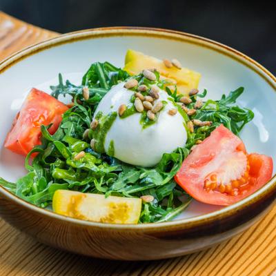 Burrata salad, with arugula, tomato, pesto, and pine nuts.