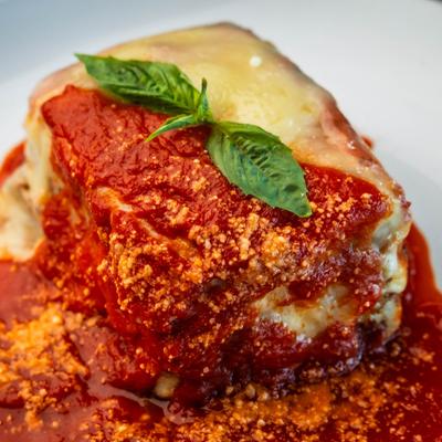 Lasagna, smothered in red sauce.