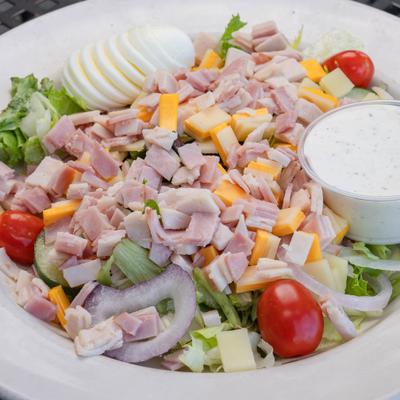 Chefs Salad with sliced turkey and ham, hard-boiled egg, grated cheese and a dressing.