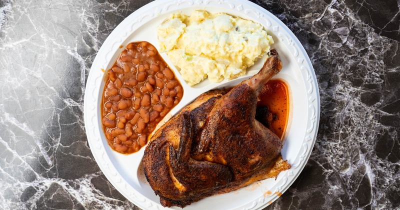 Half barbecue chicken with potato salad and baked beans
