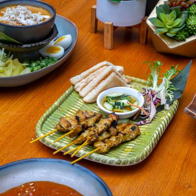Grilled marinated pork satay with toast and a cucumber salad, accompanied by crab meat curry.