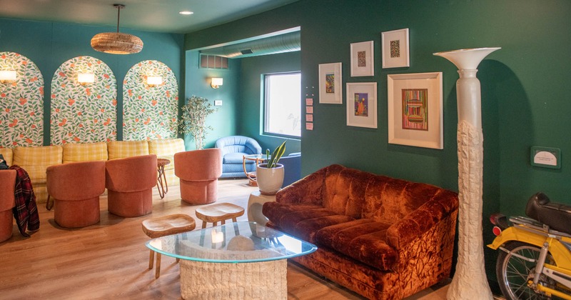 Interior, seating area, two seater sofa with small stools and glass top coffee table