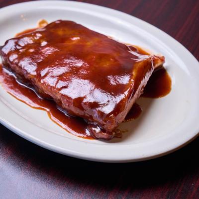 BBQ baby ribs on a white plate.