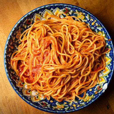 Spaghetti marinara served on a decorative plate with floral pattern.