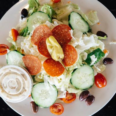 Salad with olives, iceberg lettuce, pepperoni, cucumber, cherry tomato, sausage and mozzarella