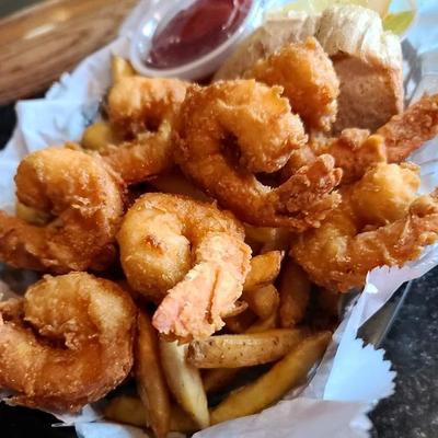 Shrimp fry served over fries with a dipping sauce.