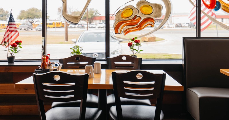 Interior, table for four ready for guests, shop window with painted food dishes