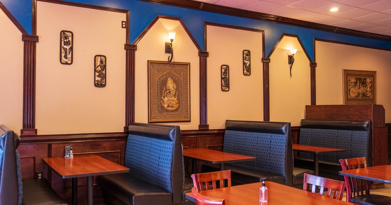 Interior seating area with tables and booths, traditional Thai decoration