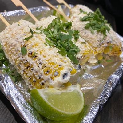 Street corn topped with cheese, mayo, and cilantro.