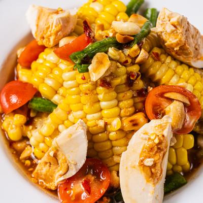 Tum Spicy Corn salad with tomatoes, salted egg and lime dressing.