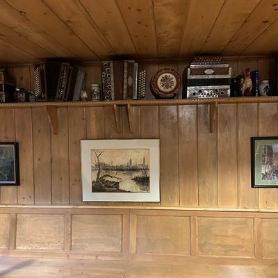 Interior with wood paneling, wall art, and decorative accordions on a shelf.