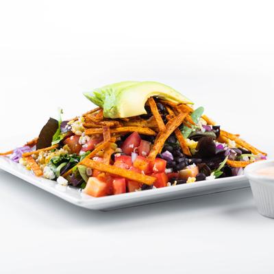 Southwest salad topped with avocado slices and crispy tortilla strips.