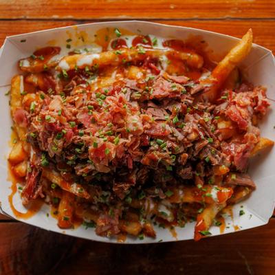 Loaded fries, with cheese, BBQ sauce, ranch dressing, bacon bits, and chives.