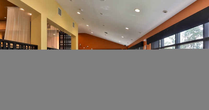 Interior, tables set with white tablecloths and red napkins, wooden chairs, tile flooring