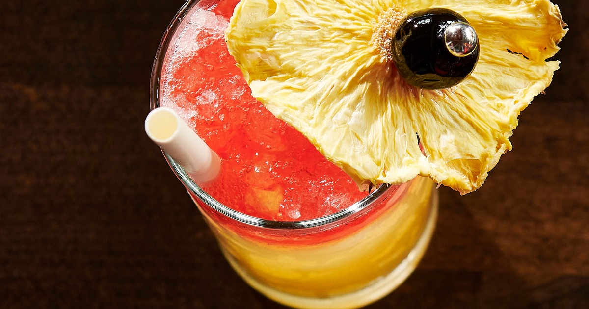 Tropical cocktail with pineapple garnish and a cherry on top