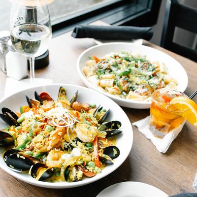 Seafood paella and Rasta pasta served with white wine and Old Fashioned.