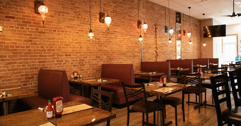 Seating area, wall of bricks, tables, chairs and booths