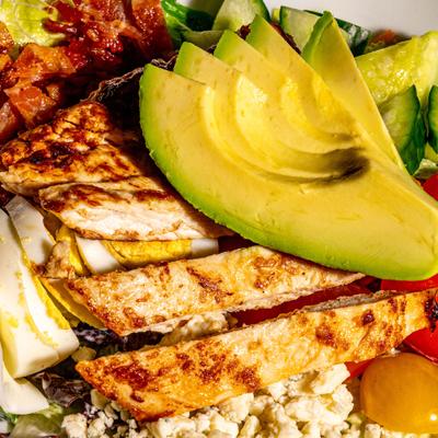 Cobb salad with grilled chicken and avocado, close-up.