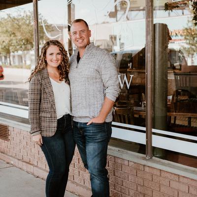 Portrait of owners standing by the restaurant's window outside