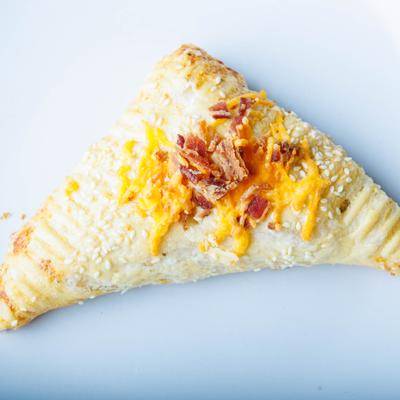 Breakfast Scone topped with grated cheese and bacon bites.
